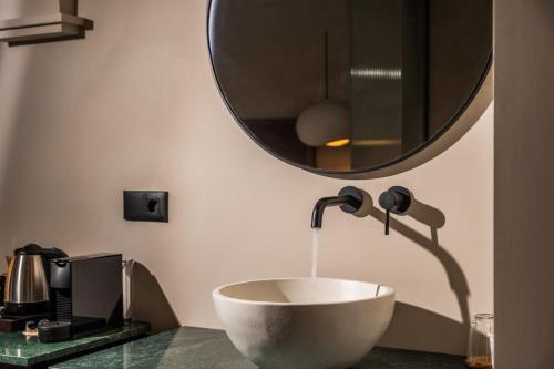 a bathroom with a bowl sink and a mirror at Astoria Hotel in Agia Galini