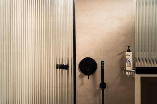 a shower door in a bathroom with a bottle of soap at Astoria Hotel in Agia Galini