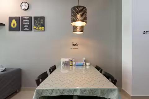 a dining room with a table with chairs and a clock at SS15 Courtyard Subang Jaya Sunway Home Cinema Projector Studio 120 Inches in Subang Jaya