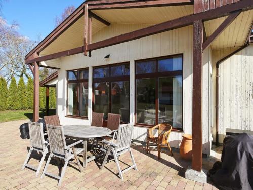 a patio with a table and chairs and a house at 6 person holiday home in Kirke Hyllinge in Kirke-Hyllinge
