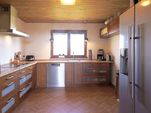a large kitchen with wooden cabinets and a window at 6 person holiday home in Kirke Hyllinge in Kirke-Hyllinge