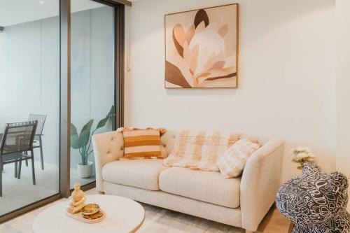 a living room with a couch and a table at 2BR Queens Wharf Residence Level 27 Sky Deck & River View w Carpark in Brisbane