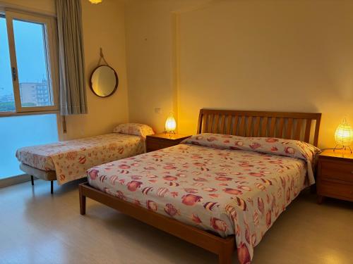 1 dormitorio con 2 camas, 2 lámparas y una ventana en Attico Vista Mare, en Lido di Jesolo