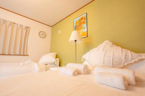 a bedroom with a white bed with towels on it at ｄｐ小山町 in Machida