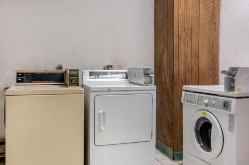 a laundry room with a washing machine and a washer at Forsythia Inn & Suites in Forsyth