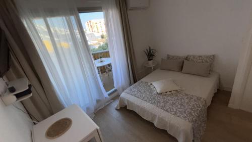 a small bedroom with a bed and a window at 1ere ligne, Vue mer, piscine privée, Wifi, Clim in La Grande-Motte