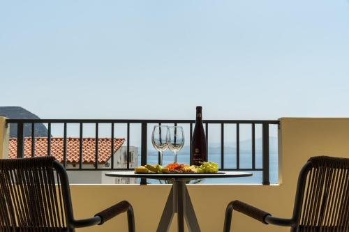 a table with two chairs and a glass of wine at Astoria Hotel in Agia Galini