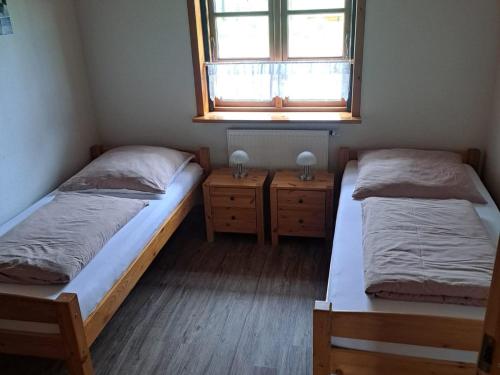 two beds in a small room with a window at Ferienhof Schlottmann in Achtrup