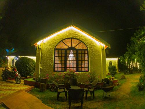 a green house with a window with lights on it at LA Address Retreat - The Heritage Homestay in Ooty