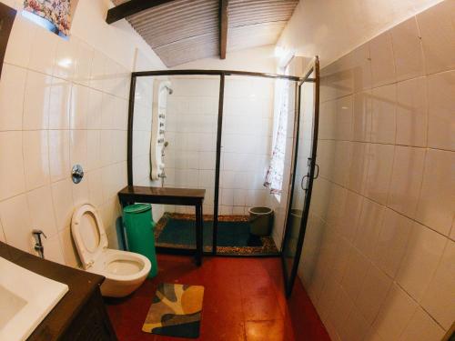 a small bathroom with a toilet and a shower at LA Address Retreat - The Heritage Homestay in Ooty