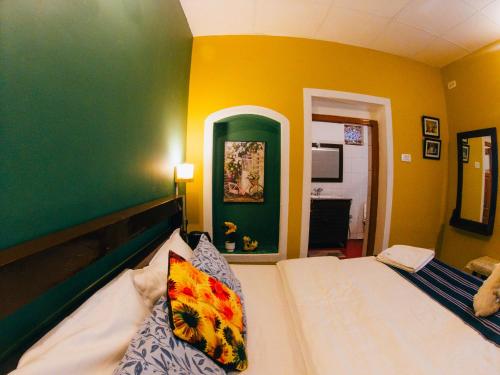 a bedroom with a bed and a green and yellow wall at LA Address Retreat - The Heritage Homestay in Ooty