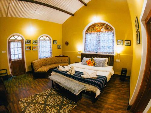 a bedroom with a large bed and a couch at LA Address Retreat - The Heritage Homestay in Ooty