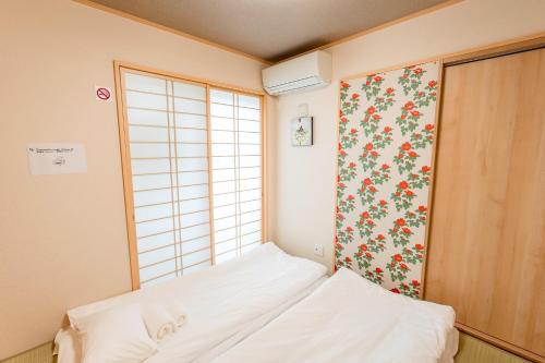 a small room with a bed and a window at ｄｐ小山町 in Machida