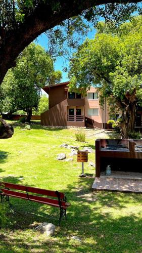 a park bench in front of a building at Tata Inti Complejo Serrano in Merlo