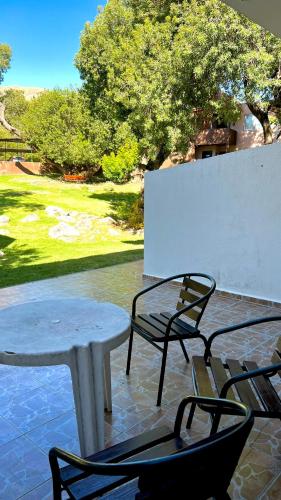 a table and chairs on a patio with a table and chairs at Tata Inti Complejo Serrano in Merlo