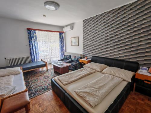 a bedroom with a bed and a couch at OPEN Vendégház in Sopron
