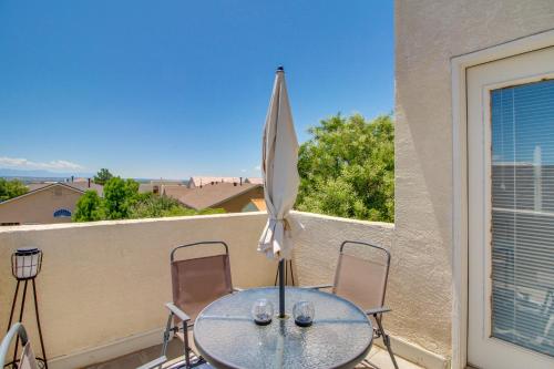 a table with two chairs and an umbrella on a balcony at Explore ABQ and Rancho Rio Family Home with Patios! in Rio Rancho