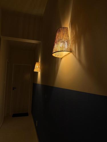 a room with two lights on the wall at Mirante do Ipiranga Apartment in Guarapari