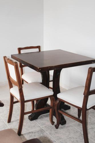 a wooden table with two chairs and a table and a table and chairs at Kunan Hotel in Cochabamba