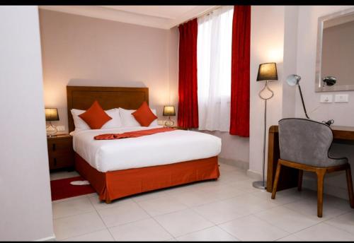 a bedroom with a bed and a desk and a chair at Queen Hotel in Addis Ababa