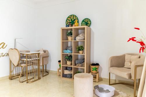 una stanza con uno scaffale con piante in vaso e un tavolo di Riad Dar JuMa Marrakech Suites & Penthouse avec Jacuzzi, Piscine chauffée & Spa a Marrakech