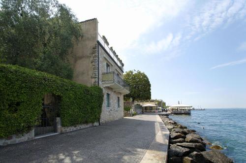 a building next to a body of water at Appartamento a 5 metri dal lago in Torri del Benaco