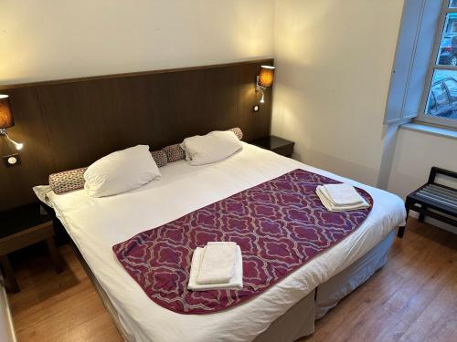 a bedroom with a large bed with two towels on it at Charmant appartement RDC familial ou pour le travail in Uzerche