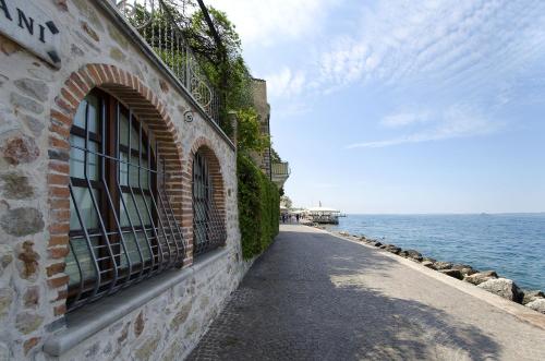 a brick building with a window next to the water at Appartamento a 5 metri dal lago in Torri del Benaco