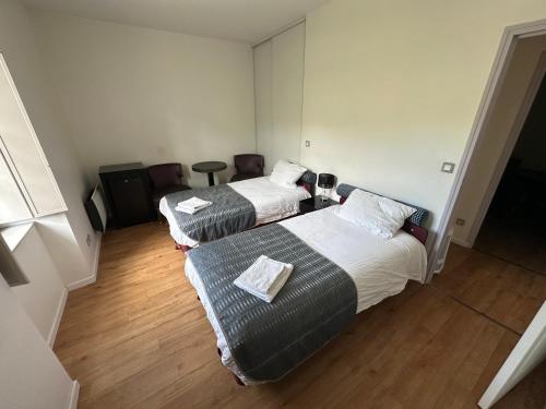 a hotel room with two beds and a couch at Charmant appartement RDC familial ou pour le travail in Uzerche
