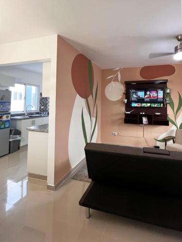 a living room with a flower mural on the wall at Apartment near the airport in Boca Chica