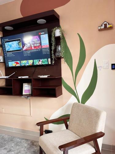 a living room with a chair and a tv at Apartment near the airport in Boca Chica