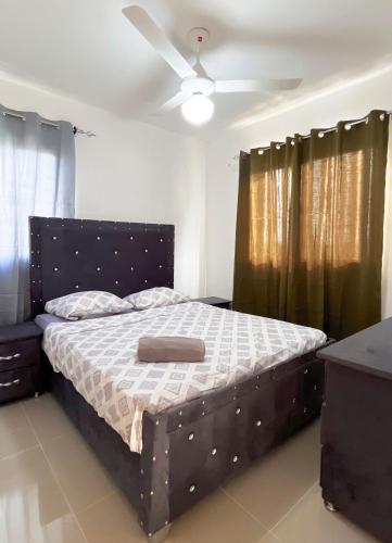 a bed in a bedroom with a ceiling fan at Apartment near the airport in Boca Chica