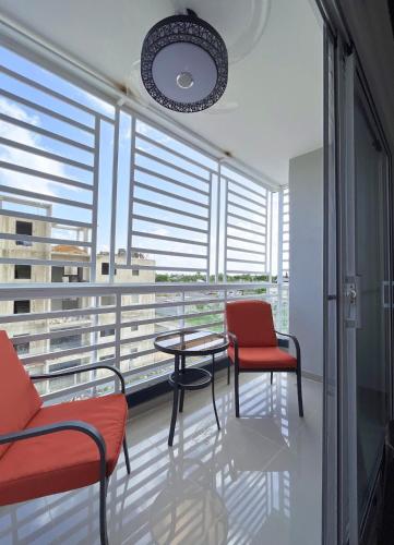 a room with two chairs and a table on a balcony at Apartment near the airport in Boca Chica