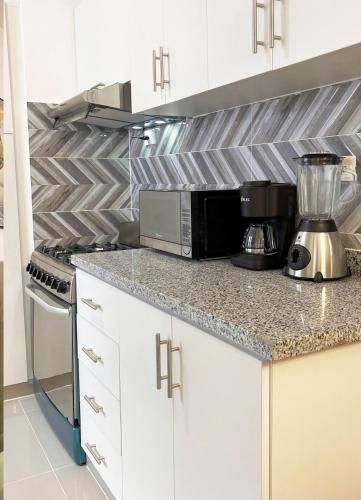 a kitchen with a counter top with a microwave at Apartment near the airport in Boca Chica
