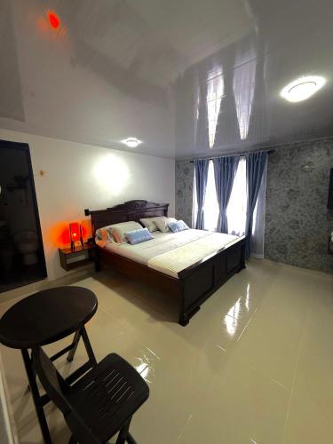 a bedroom with a bed and a chair and a table at Hotel Casa Bambu in Darién