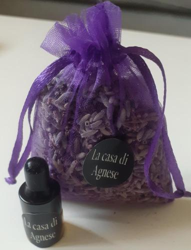 a purple bag with a bottle of lipstick next to it at La Casa di Agnese in San Benedetto Val di Sambro
