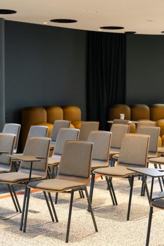 an empty room with chairs in a room at Radisson Hotel Reims in Reims