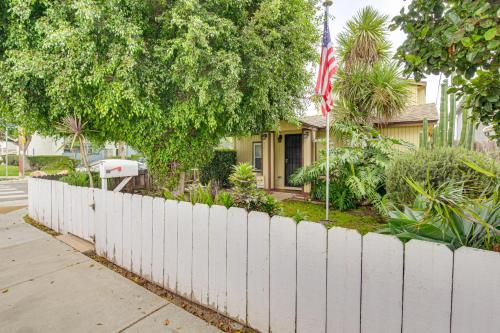 a white fence in front of a house with a flag at 2 Mi to Ocean Pet-Friendly Imperial Beach Retreat in Imperial Beach