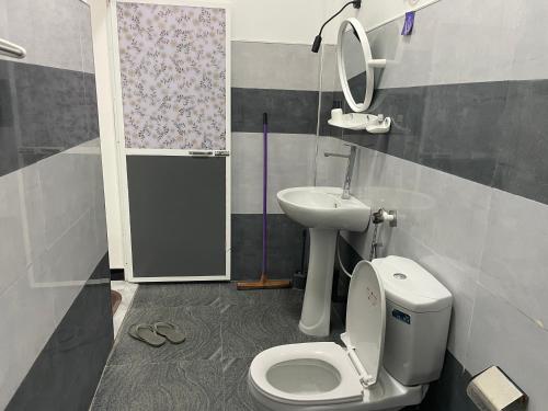 a bathroom with a toilet and a sink at Sea View Resort in Kallady
