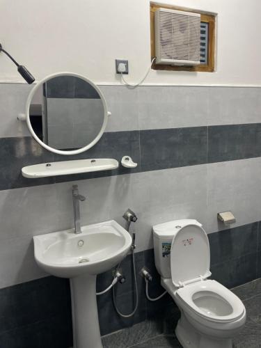 a bathroom with a sink and a toilet and a mirror at Sea View Resort in Kallady