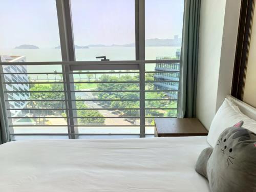 a bedroom with a bed and a large window at Huafu Seaview Suites in Zhuhai
