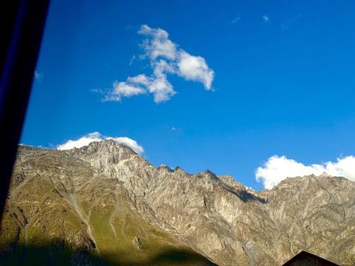 a view of a mountain range with a blue sky at Hotel Daba Kazbegi in Stepantsminda