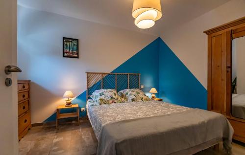 Schlafzimmer mit einem Bett mit blauem Akzent in der Unterkunft Le Rayon de Soleil in Saint-Georges-de-Didonne