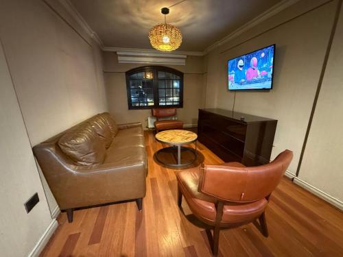 a living room with a couch and a table and a tv at Torremolinos departamentos in Temuco