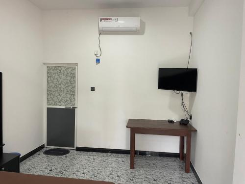 a room with a desk and a television and a table at Sea View Resort in Kallady