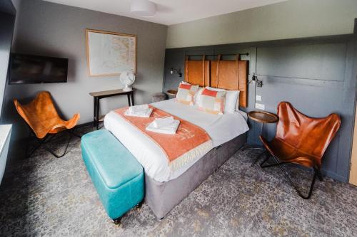 a bedroom with a large bed and chairs in it at The Hebridean - Rooms & Apartments in Broadford