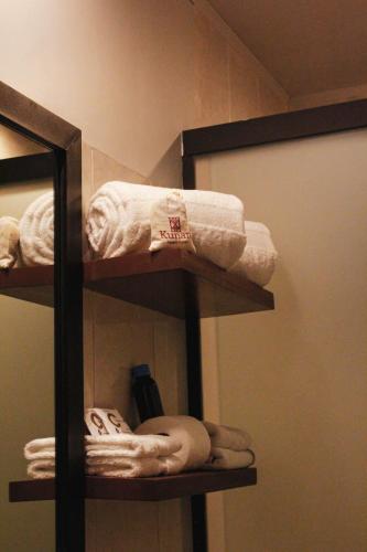 a bathroom shelf with towels and a mirror at Kunan Hotel in Cochabamba