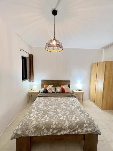 a bedroom with a large bed and a light at Be Happy Three-Bedroom Apartment in St. Paul's Bay