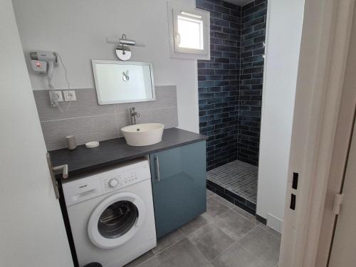 a bathroom with a washing machine and a sink at COSYLOC studios in Cergy