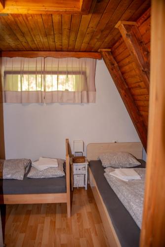 two twin beds in a room with a window at Wooden Cottage in Jesenice